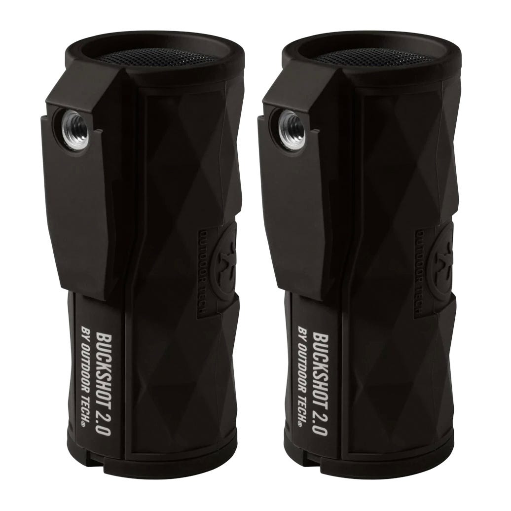 Two black Buckshot 2.0 wireless speakers by Outdoor Tech, featuring a rugged, cylindrical design with a built-in handle and grill, suitable for outdoor use.