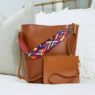 A brown leather shoulder bag with a colorful woven strap.