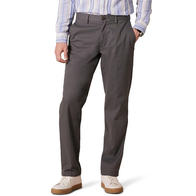 A man is wearing dark gray chinos paired with a light blue and white striped shirt and white sneakers.