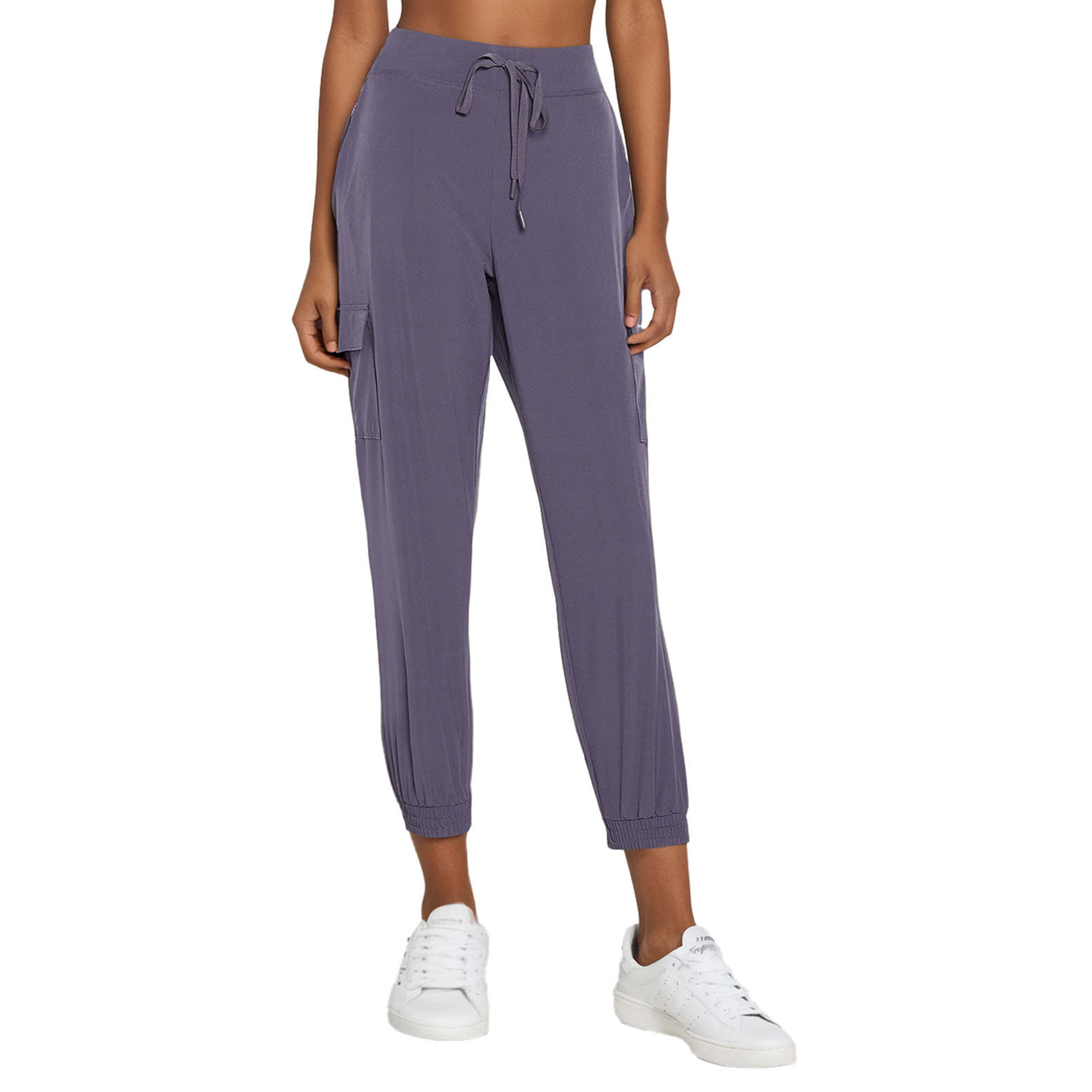 Dark purple joggers with a drawstring waist, cargo pockets on the sides, and elastic cuffs at the ankles. Paired with white sneakers.