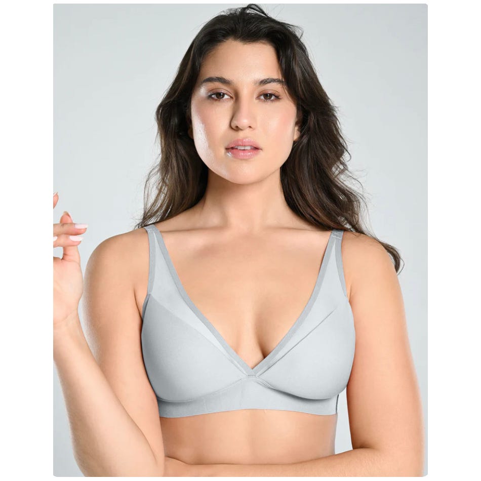 A woman is wearing a gray bra with adjustable straps.