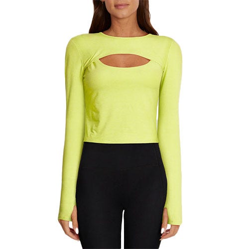 The Larissa Long Sleeve Top is a vibrant yellow-green crop top featuring long sleeves and a front cut-out detail at the neckline. It is paired with high-waisted black leggings.