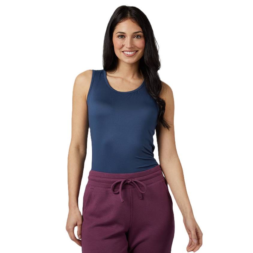 A woman is wearing a Cool Fitted Bra Tank, which is a sleeveless, dark blue top with a scoop neckline, paired with high-waisted burgundy sweatpants that feature a drawstring.
