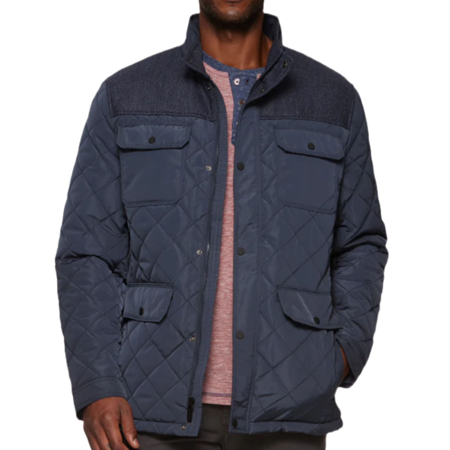 The Flag & Anthem Mixed Media Jacket is a navy quilted jacket with a button-up front, featuring two chest pockets and two lower flap pockets. It has a contrasting fabric on the shoulders and collar for added style.