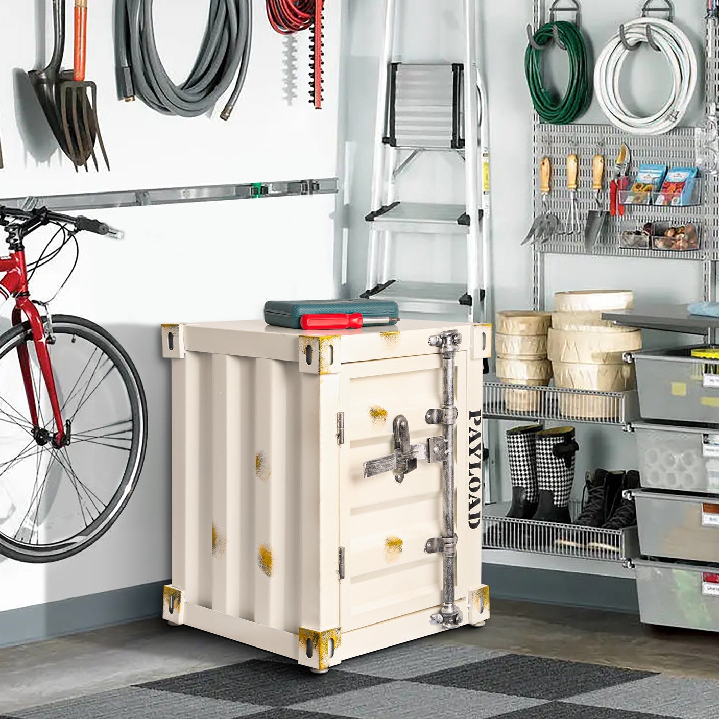 A cream-colored cargo box with metal clasps and corners, various garden tools, cables, a ladder, and storage shelves in a garage.