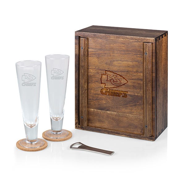 NFL Pilsner Gift Set includes two clear pilsner glasses, each with a wooden coaster, a metal bottle opener, and a wooden box featuring the Kansas City Chiefs logo.