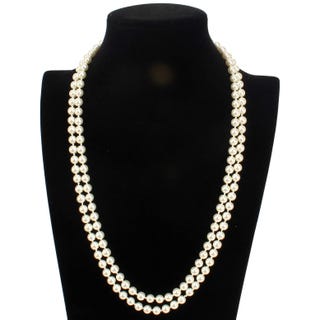 A double strand of white pearl necklaces displayed on a black mannequin bust.