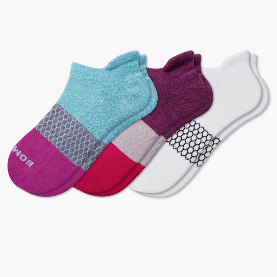Three pairs of no-show socks in turquoise, purple, and white, with contrasting patterns on the forefoot.