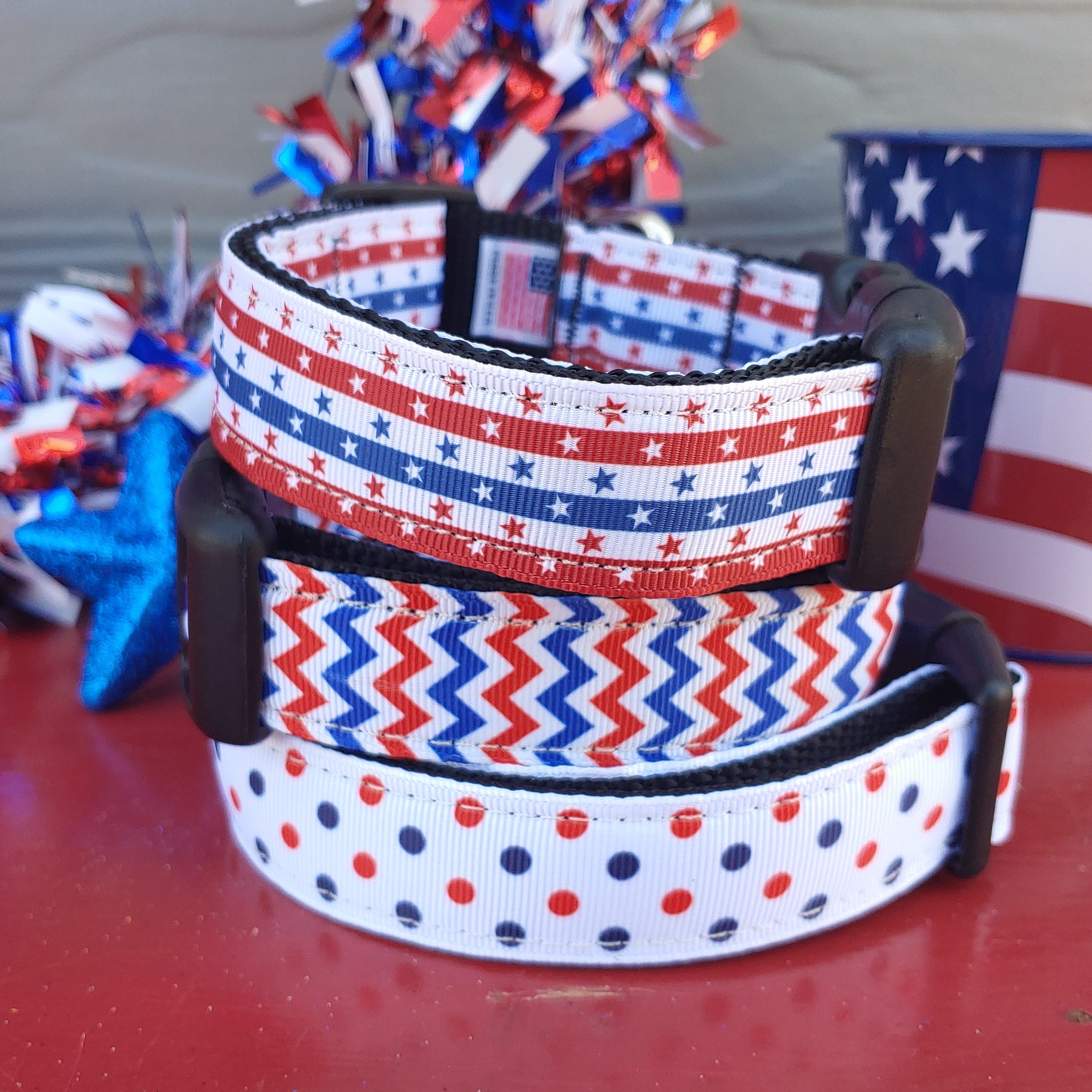 Three patriotic-themed dog collars with stars and stripes patterns in red, white, and blue colors displayed stacked.