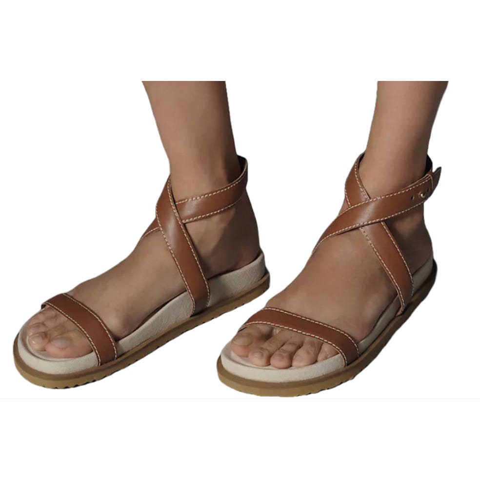 Brown leather sandals with crisscross ankle straps and a flat sole.