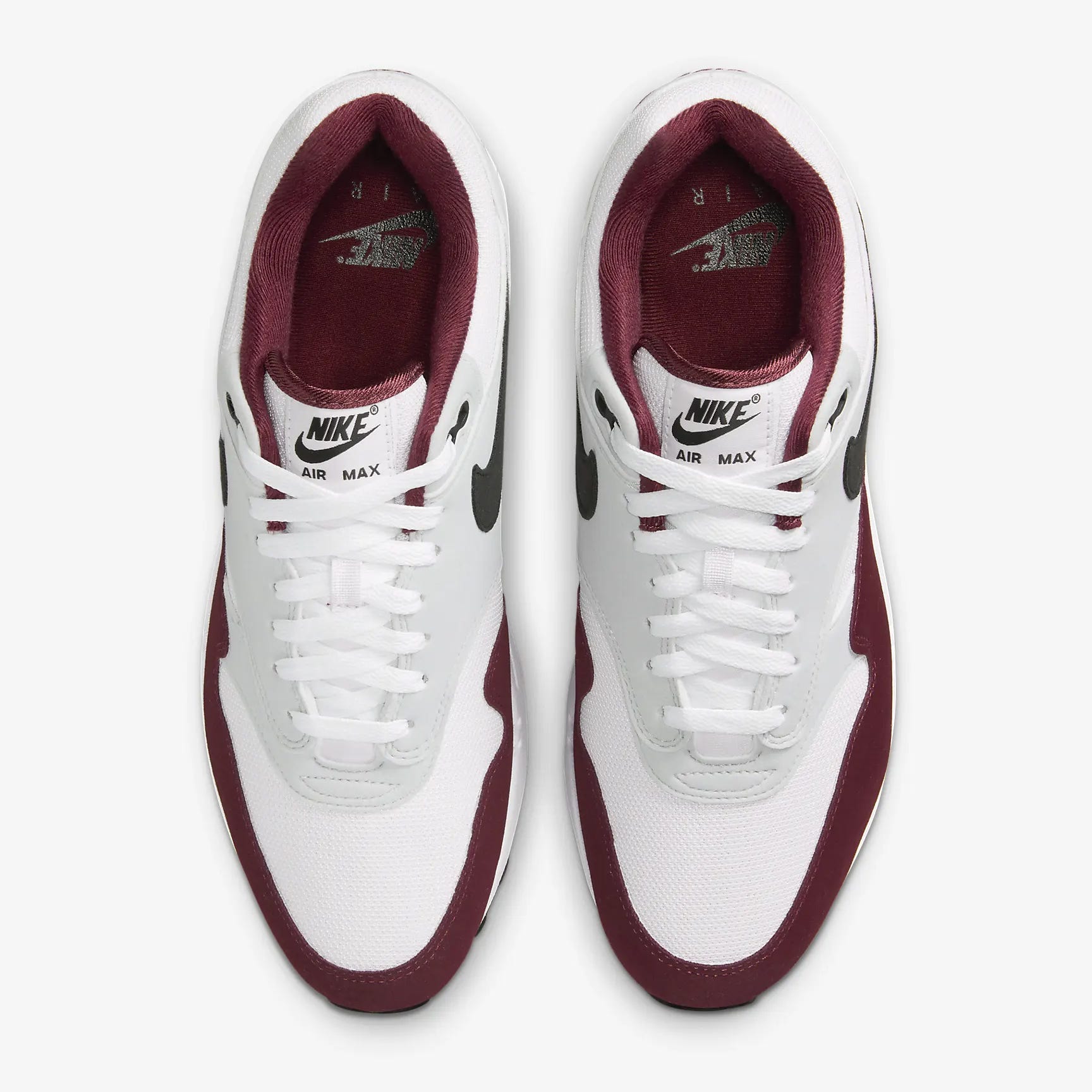 A pair of white and burgundy Nike Air Max sneakers viewed from above.