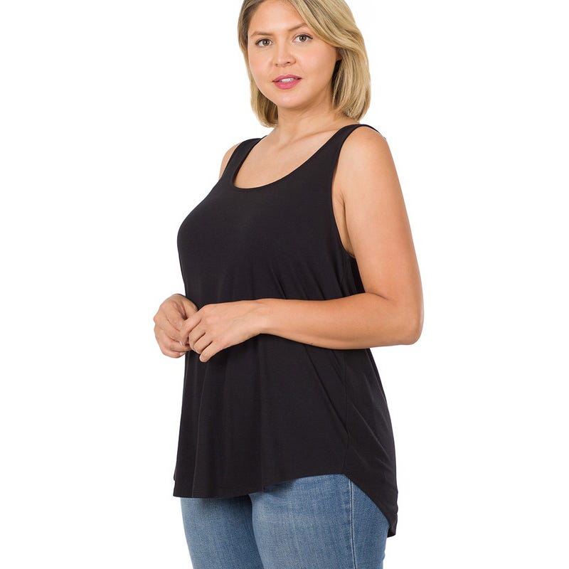 A woman wears a black sleeveless top and blue jeans.