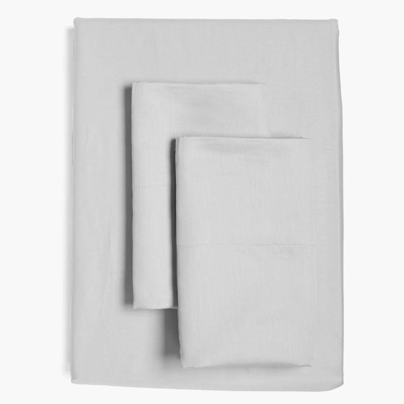 A set of white bed sheets, including a flat sheet, fitted sheet, and pillowcases.