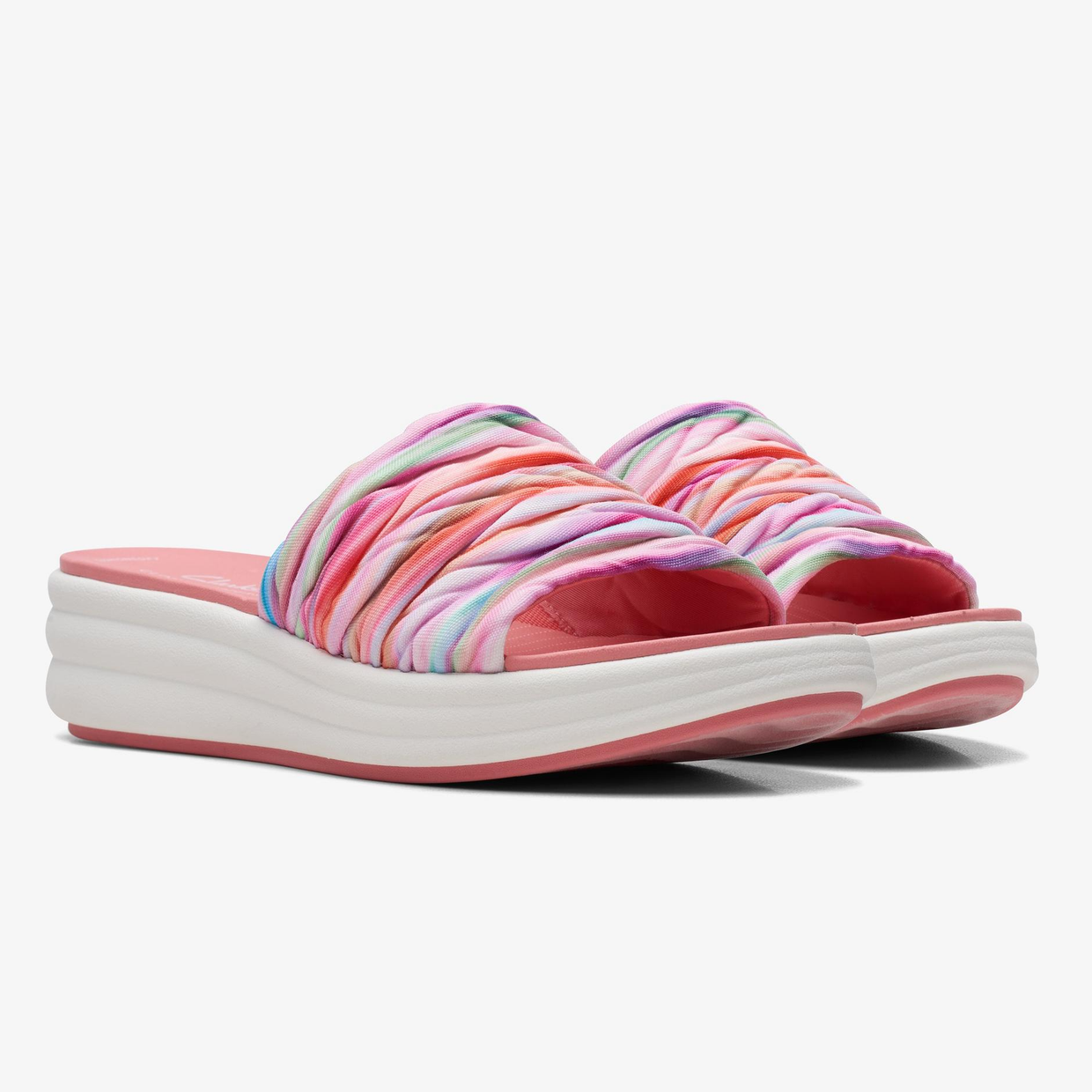 A pair of colorful striped platform sandals with a pink sole.