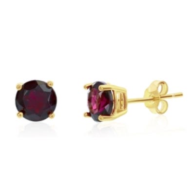 A pair of gold stud earrings featuring round, deep red gemstones in a four-prong setting.