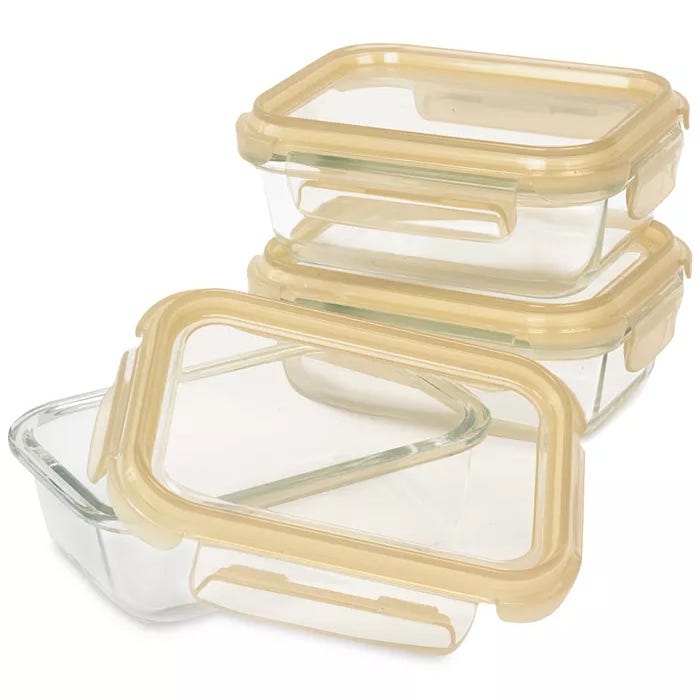 Three rectangular glass food storage containers with beige airtight lids are stacked, with one container open.