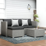 Outdoor furniture set with wicker sectional sofa, cushions, and a coffee table on a deck.
