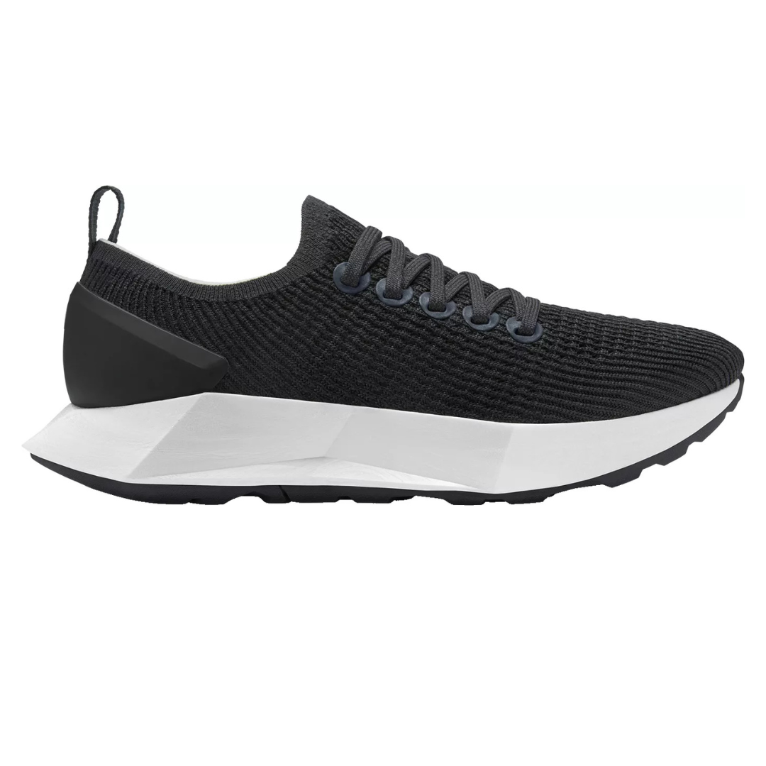 A sleek black sneaker with a textured knit upper, black laces, and a geometric white sole with a black heel cap.