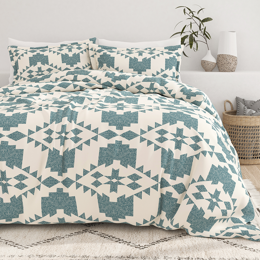 A geometric-patterned bedding set with duvet cover and pillowcases in teal and cream.
