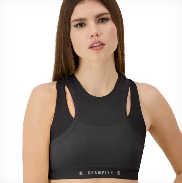 A black sports bra with a racerback design featuring cut-out details and the Champion brand logo on the elastic band.