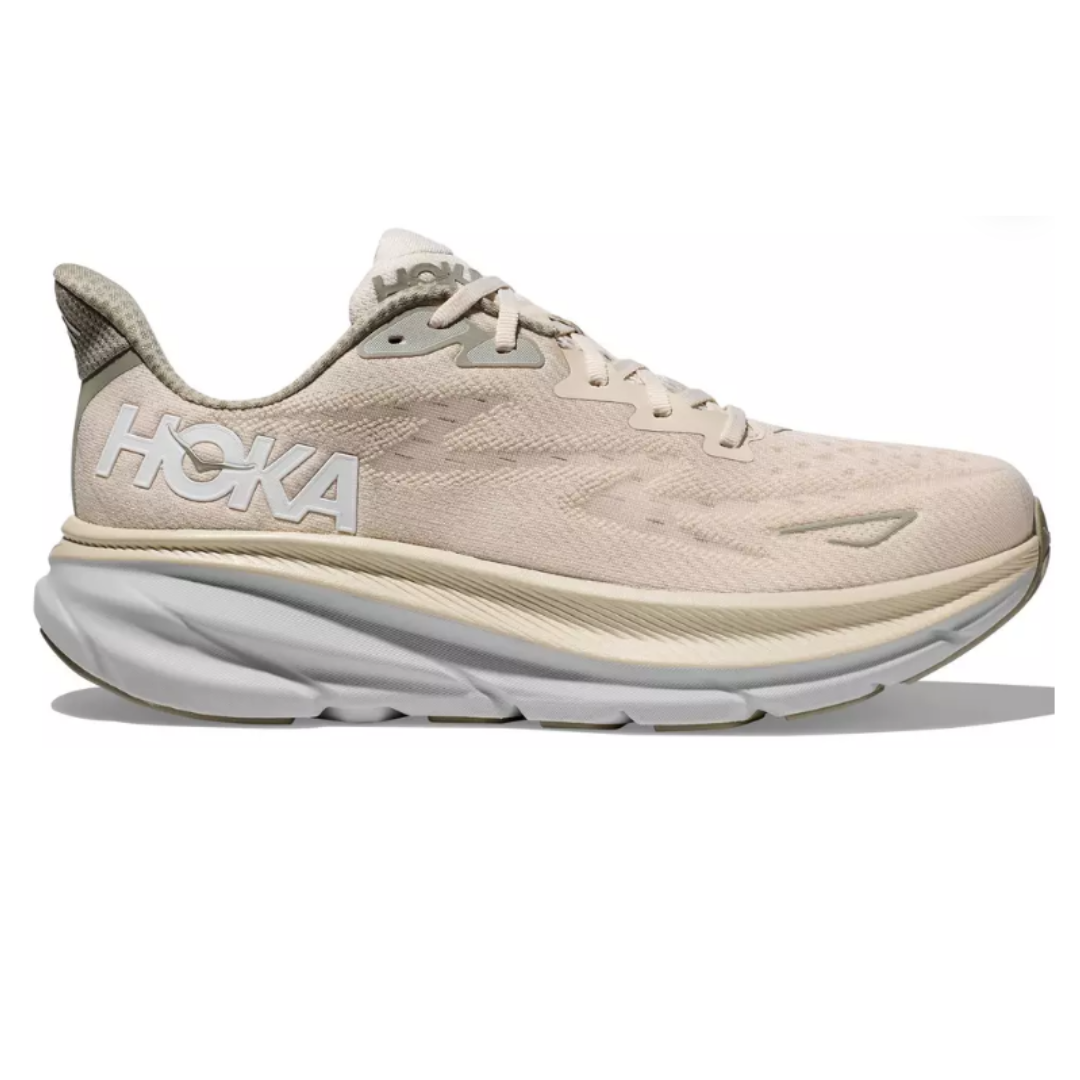 A beige Hoka running shoe featuring a thick, cushioned sole and mesh upper for breathability.