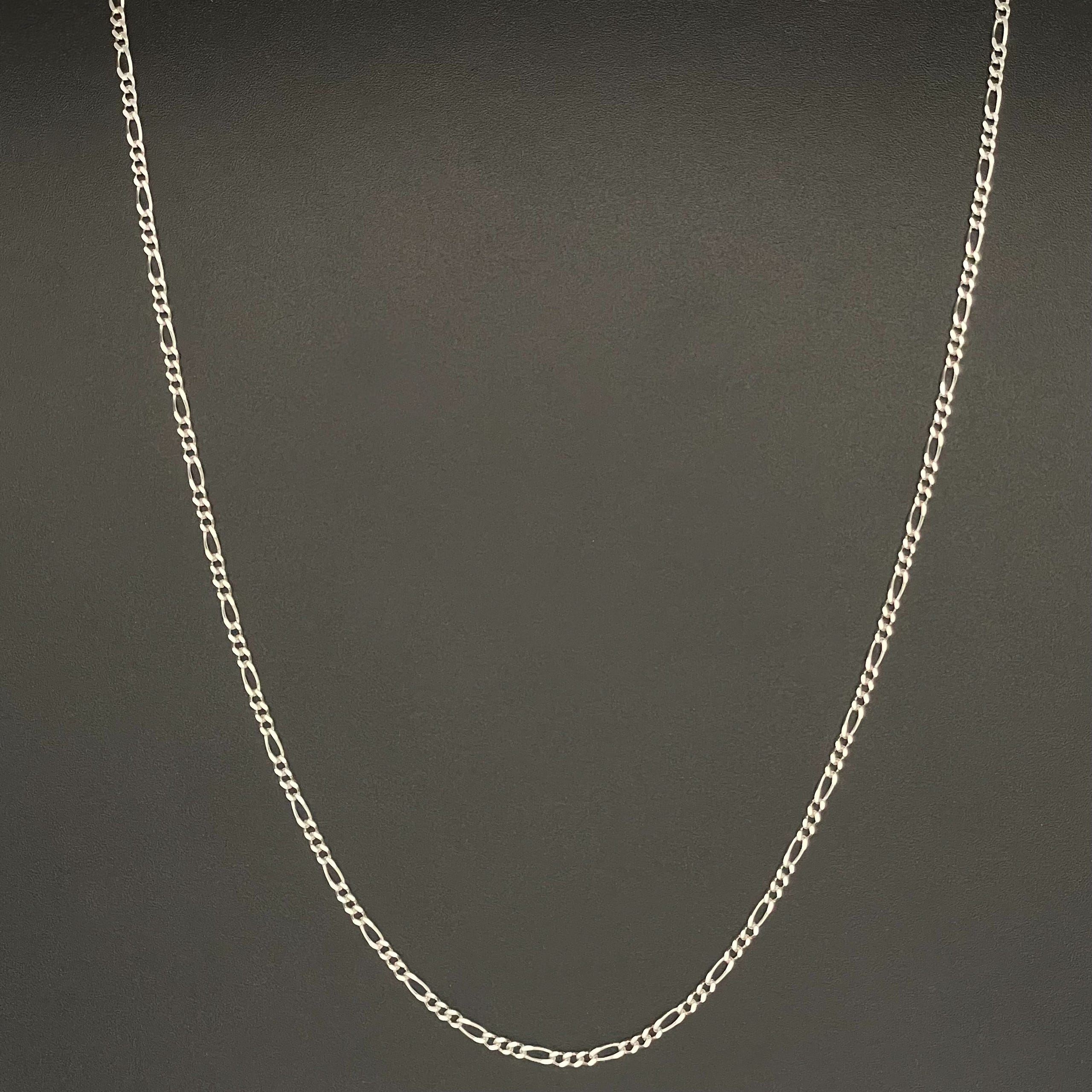 Silver chain necklace on a black background.
