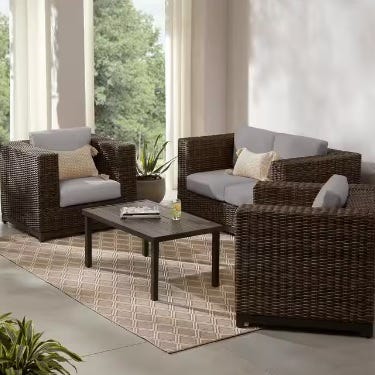 Rattan-style patio furniture set with cushions and a matching coffee table.