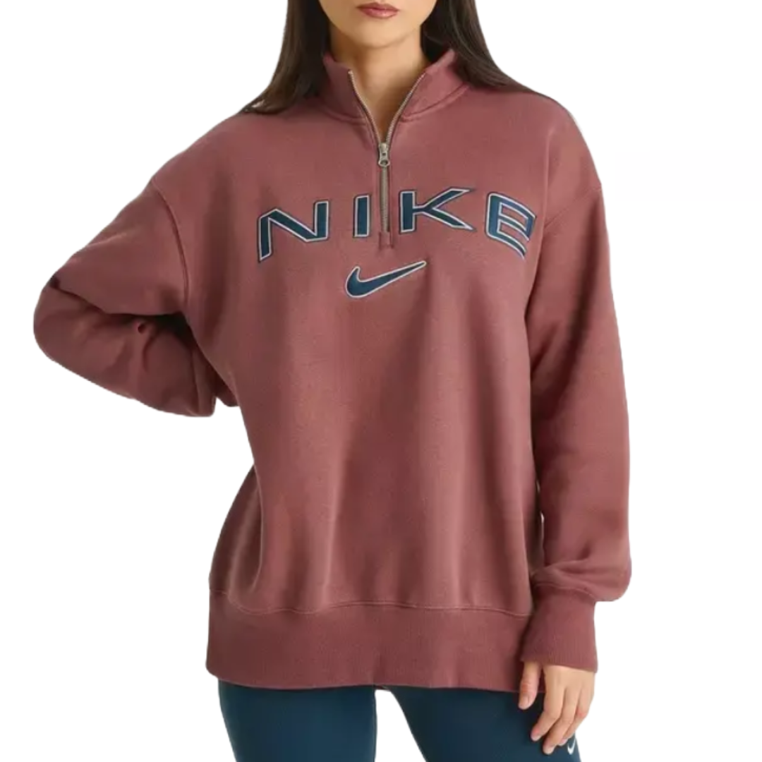 Nike oversized quarter-zip sweatshirt in a muted mauve color, featuring \“NIKE\“ and swoosh logos in blue on the front. It has long sleeves and a relaxed fit.