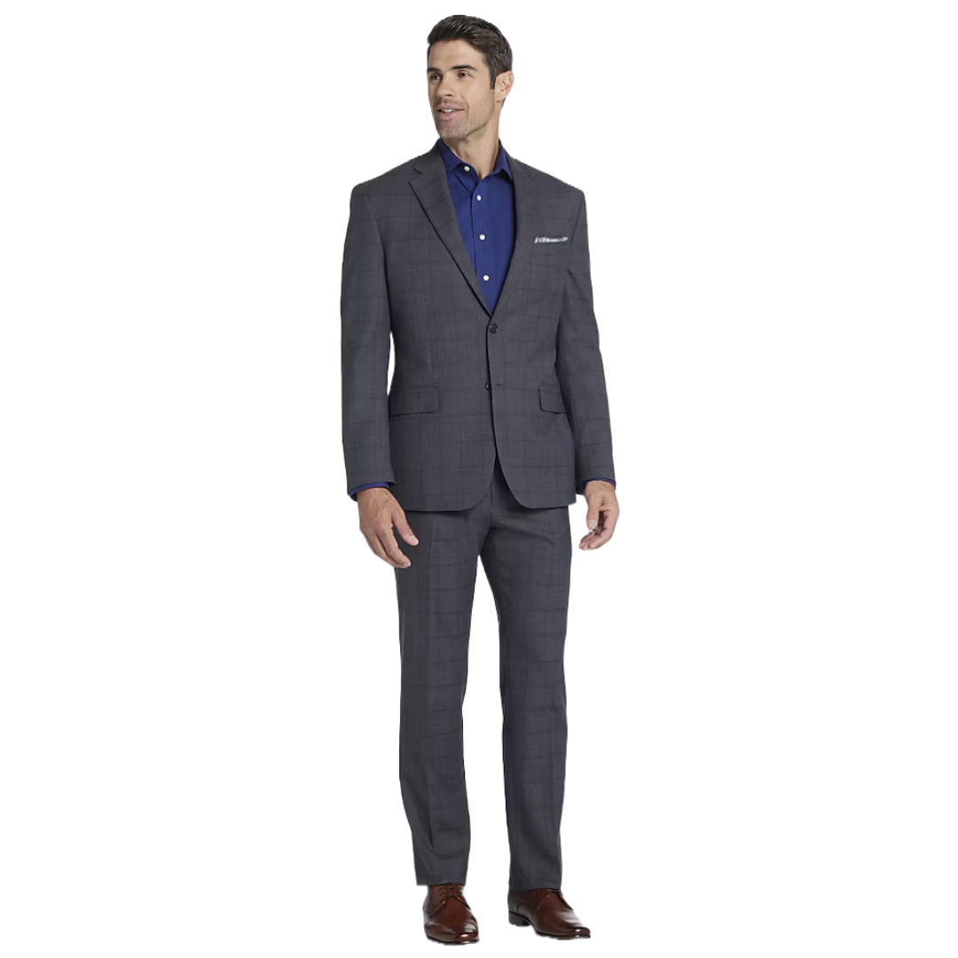 A man is wearing a gray plaid suit with a matching jacket and pants, paired with a dark blue dress shirt and brown shoes.