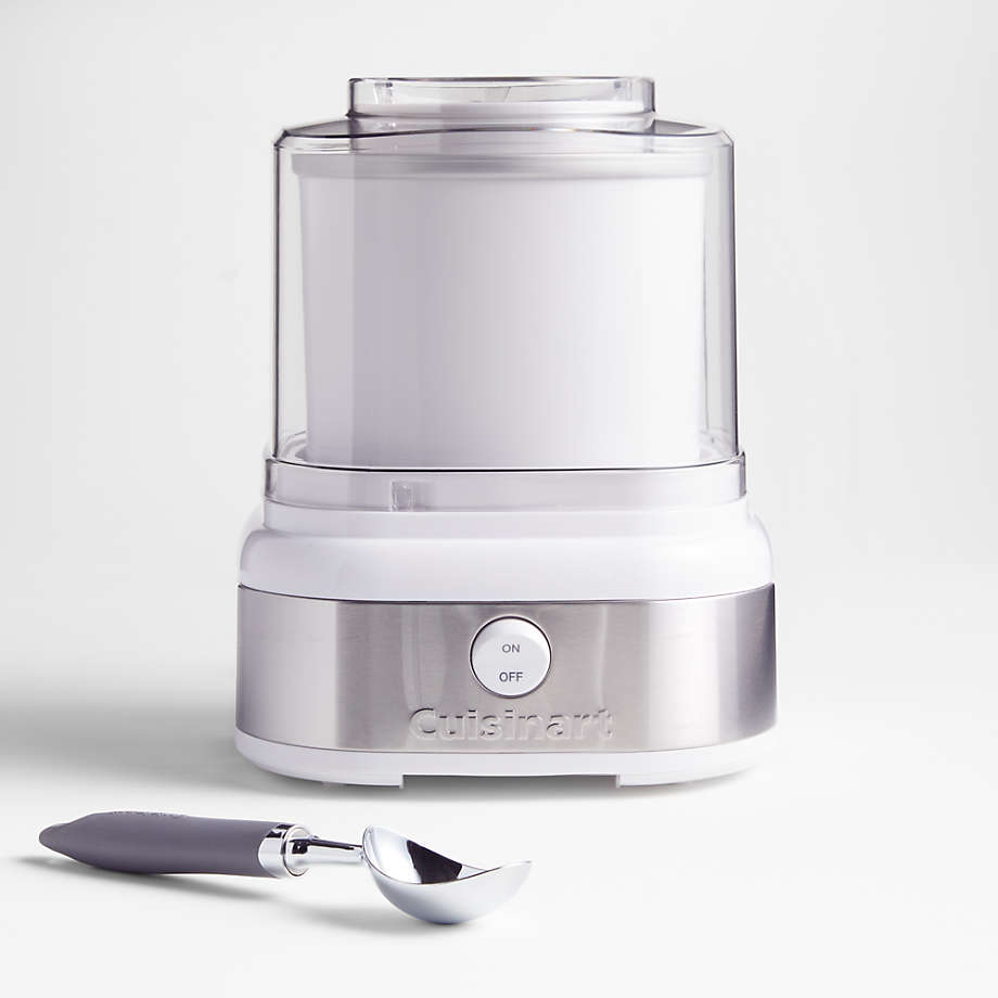 A compact ice cream maker with a silver finish and a single on/off switch, accompanied by a metal ice cream scoop.