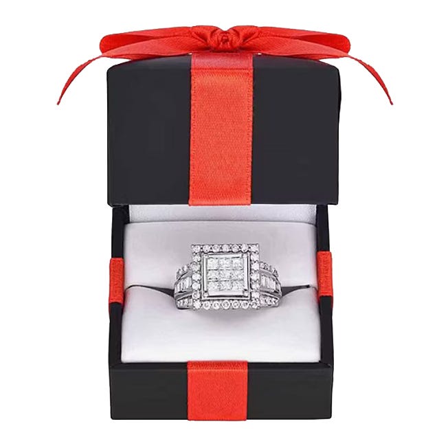 A square-cut diamond ring presented in a black box with a red ribbon.