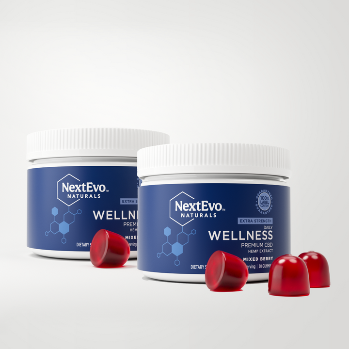 Two containers of NextEvo Naturals Extra Strength Wellness Premium CBD gummies with red gummies in front, labeled for mixed berry flavor.