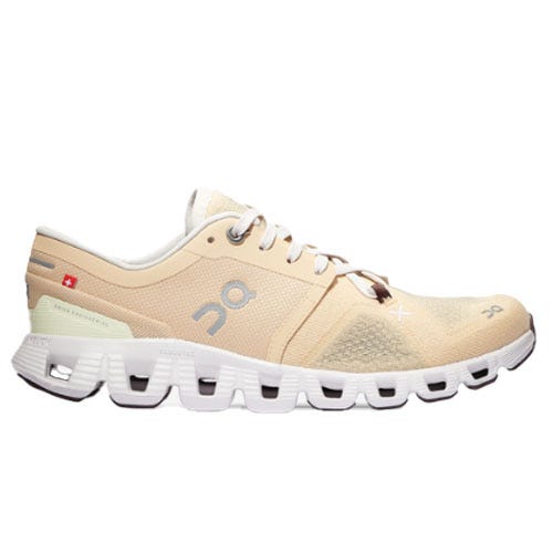 The On Cloud X Running Shoes are beige with a Swiss flag detail, featuring a breathable mesh upper and a distinctive segmented sole design for flexibility and cushioning. They have a logo on the side and offer a lightweight construction.