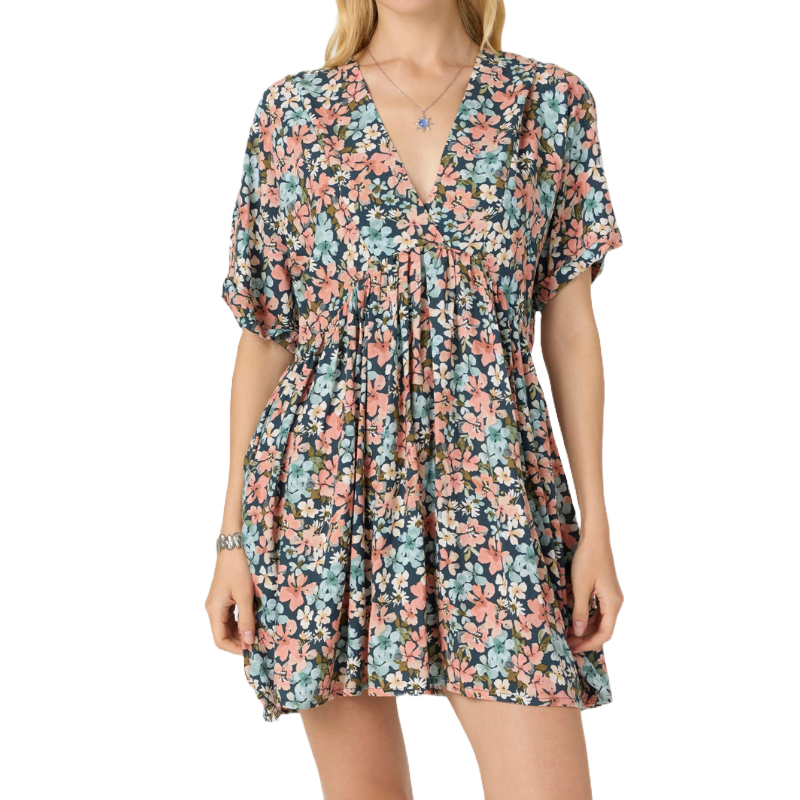 A short V-neck dress with short sleeves, featuring a multicolored floral pattern in pink, blue, and white on a dark background. The dress has a loose, flowy fit with gathering at the waist.