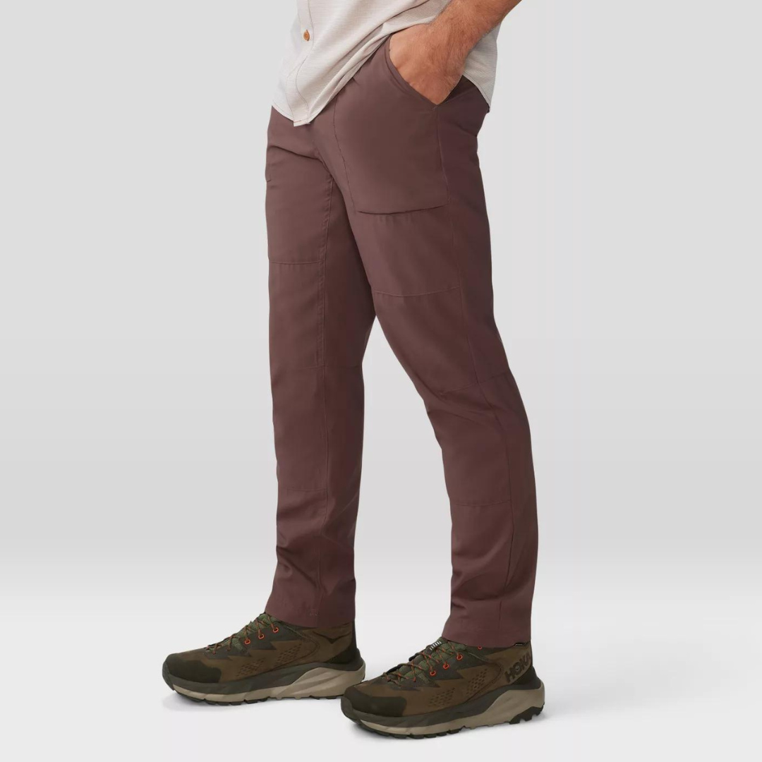 A person is wearing maroon cargo pants paired with brown and green hiking shoes.