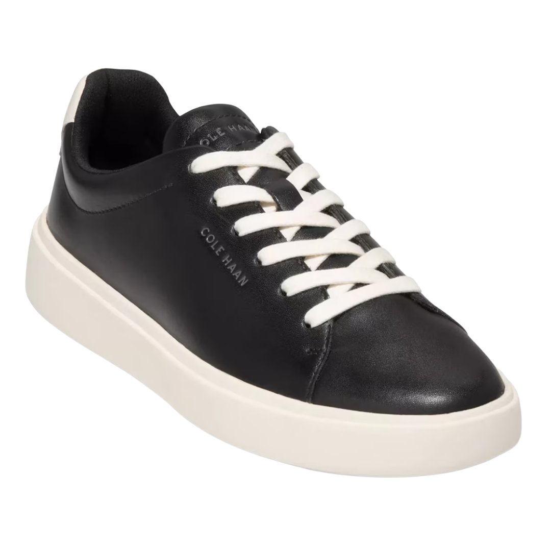 Black leather sneaker with white laces and a white sole, branded \“Cole Haan\“ on the side and tongue.
