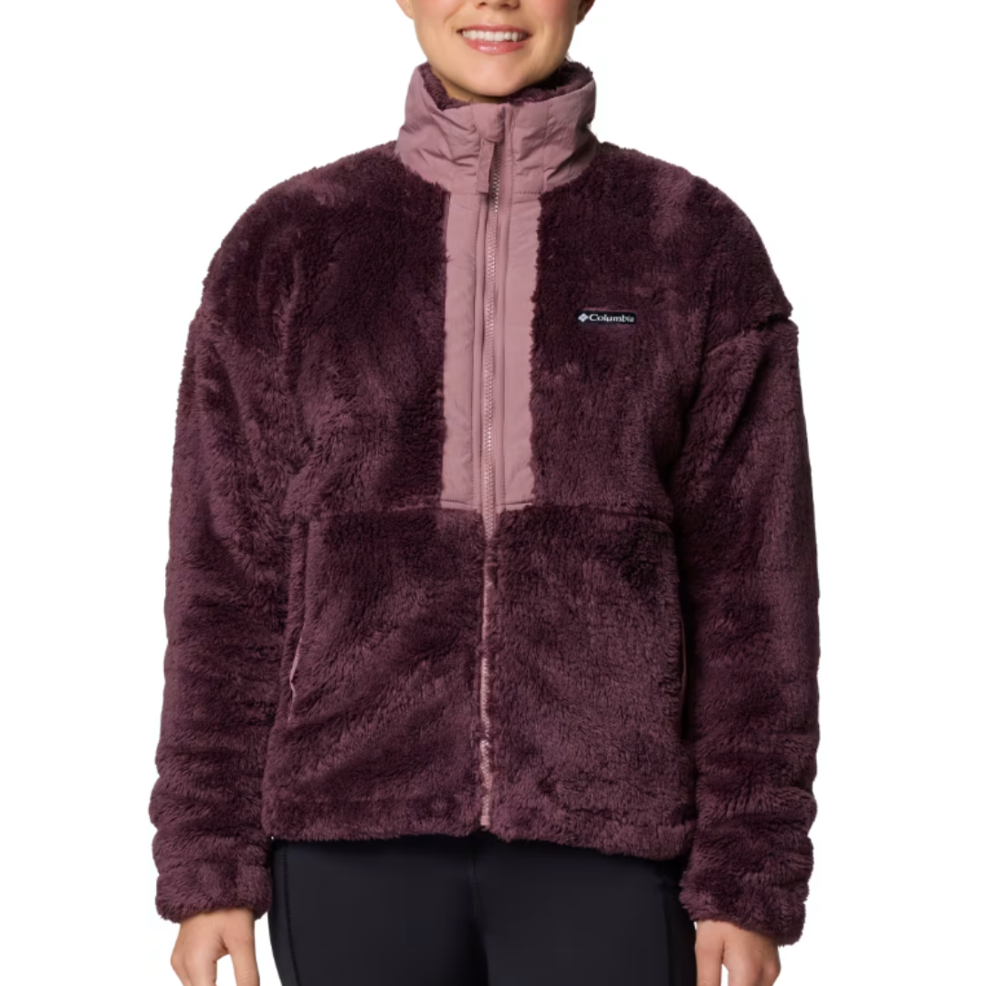 The Columbia Boundless Discovery Jacket is a plush, fleece zip-up in dark purple with a high collar and contrasting lighter purple trim. It features the Columbia logo on the chest and has a cozy, textured finish.