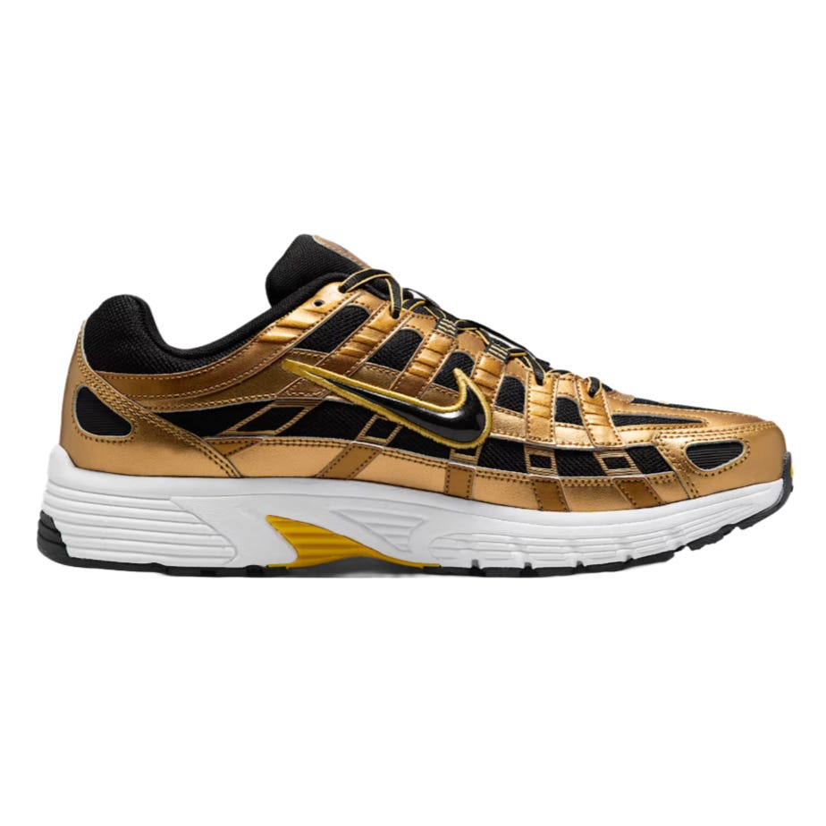 A metallic gold and black Nike sneaker with a prominent swoosh logo, featuring a white sole with black and yellow accents.