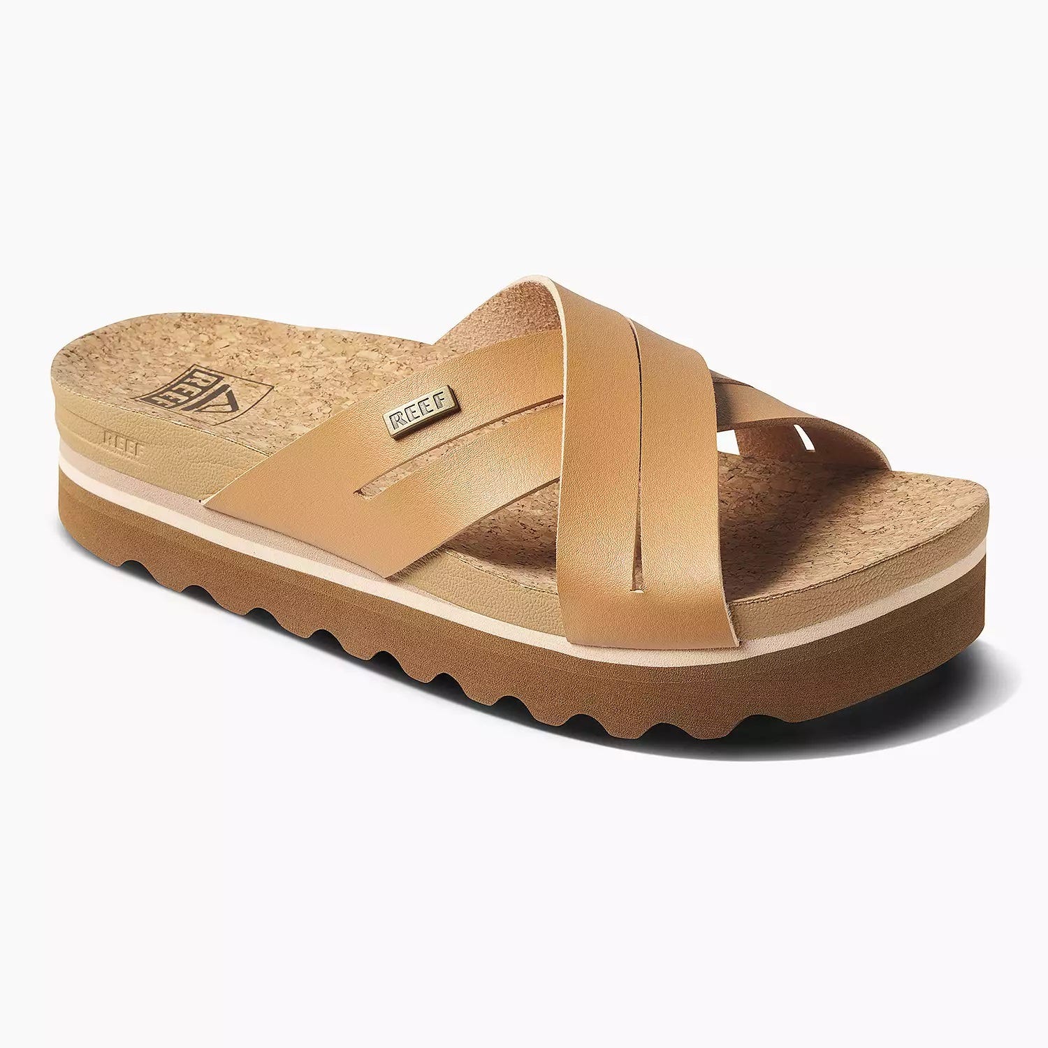 A pair of cork-soled platform sandals with wide tan straps displaying the REEF brand logo.