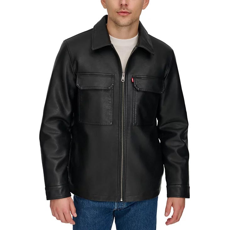 A man is wearing a black leather jacket with front zip closure and chest pockets, paired with blue jeans.