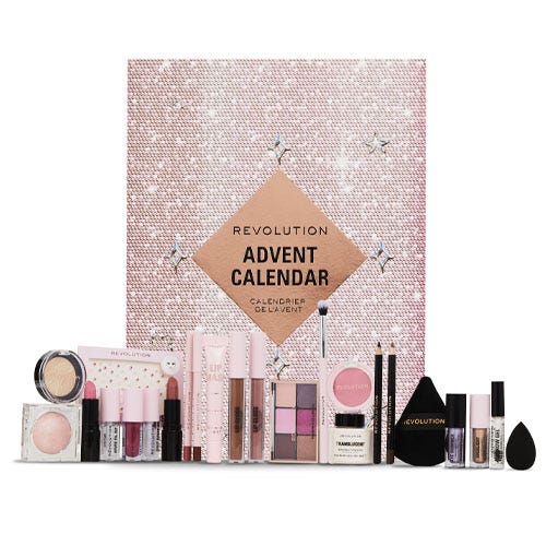 A Revolution Beauty Advent Calendar, featuring a variety of makeup items such as lipsticks, eyeshadows, brushes, and a mirror set against a sparkling pink background.