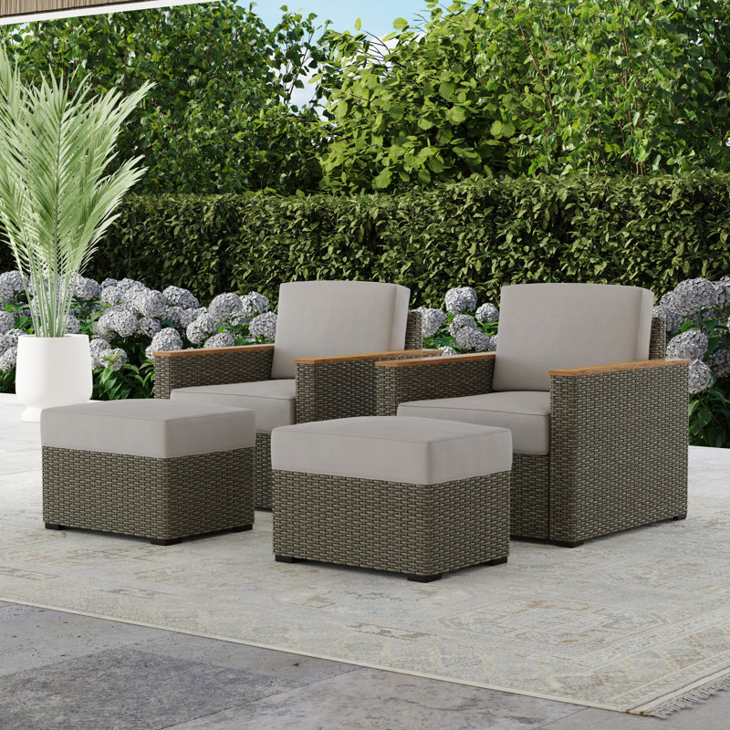 Outdoor furniture set including two chairs with beige cushions, a loveseat, and a coffee table, displayed in a garden setting.