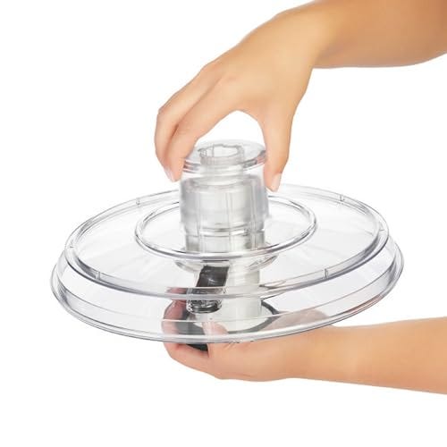 A clear OXO Salad Spinner with a hand pressing the pump mechanism on the lid, designed to wash and dry salad greens.