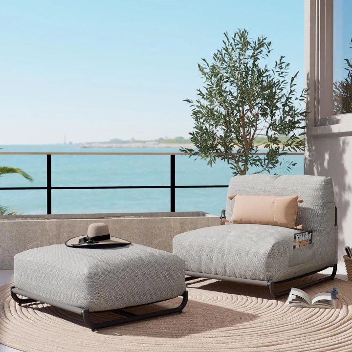 Outdoor furniture set on a balcony, including a textured grey armchair and footstool with a small round tray on top.
