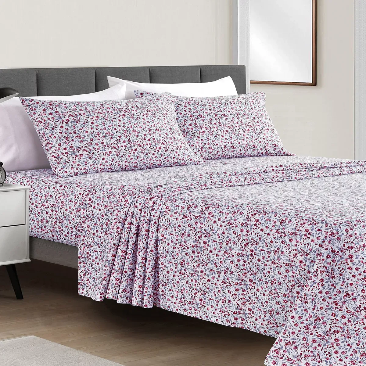 Floral patterned bedding set including fitted sheet, flat sheet, and pillowcases on a bed.