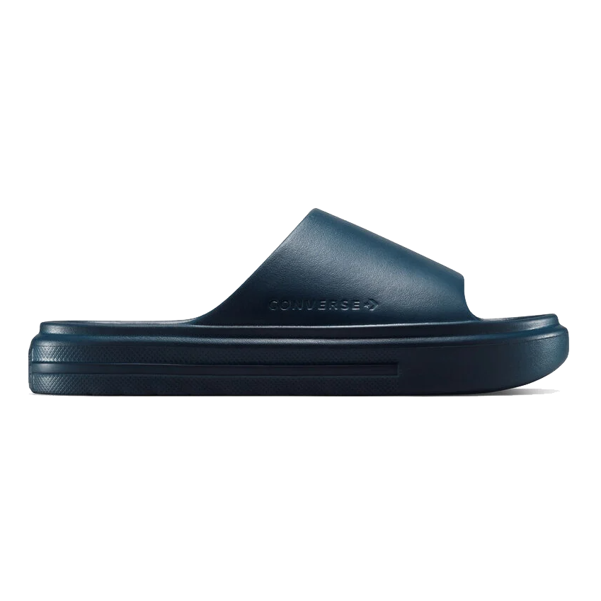 A navy blue Converse slide sandal with a single strap design and a thick sole, featuring the embossed Converse logo on the side.