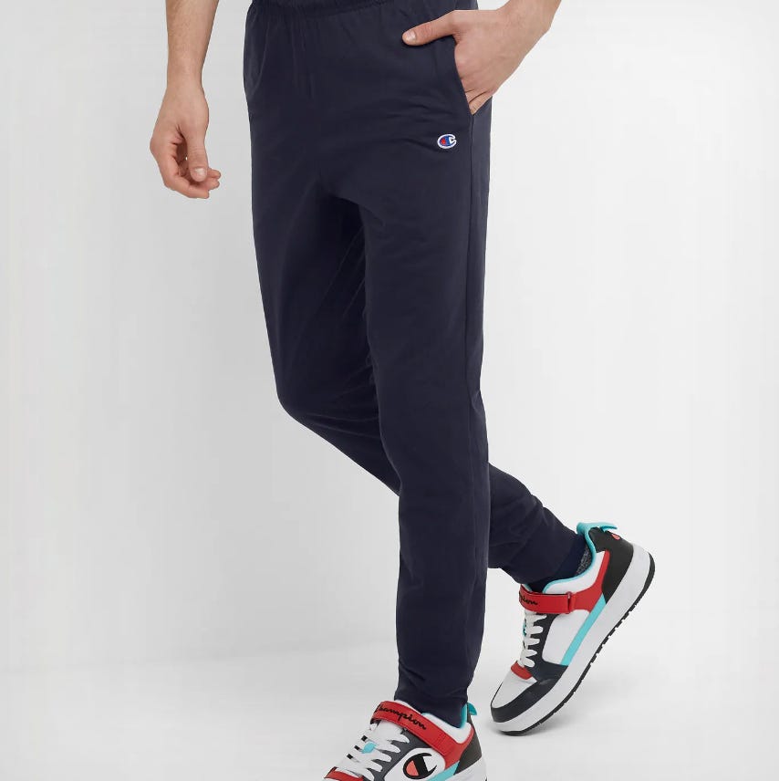Navy blue Champion joggers with a small logo on the left hip, featuring a relaxed fit and an elastic waistband with pockets.
