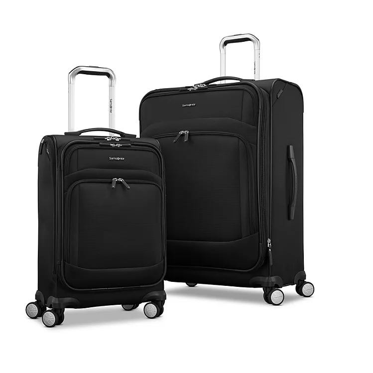 Two black Samsonite suitcases with wheels and telescoping handles; one is larger than the other.