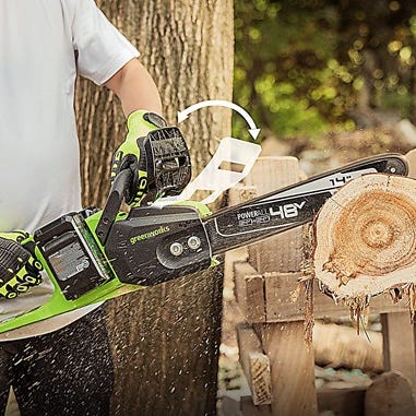 A person is using a cordless electric chainsaw to cut through a log.