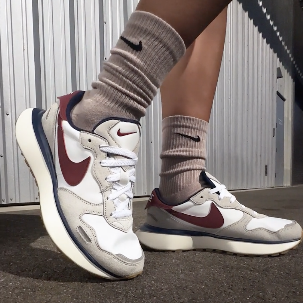 Brown crew socks and white sneakers with red and navy accents.